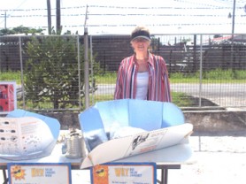 Patricia McArdle of Solar Cookers International stands behind the Cookit solar cooking apparatus.