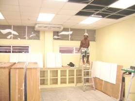 A carpenter takes a break from installing cupboards in the pharmacy.  
