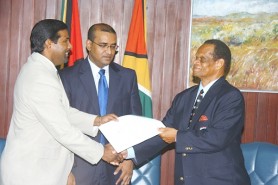 WIPA President Dinanath Ramnarine (left) and Dr Julian Hunte, WICB Presi-dent, shake hands to signify the completion of the agreement between the two parties, as CARICOM Chairman, President Bharrat Jagdeo looks on. (Office of the President photo) 