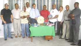 Minister of Sport Dr. Frank Anthony and 2008 NAPF Caribbean Championship best lifter Randolph Morgan hold one of the 25KG plates yesterday when the sport ministry handed over a quantity of internationally-specified weights to the GPLF. (Rawle Toney photo)  