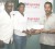 Co-Director of the Kashif and Shanghai Organization Aubrey ‘Shanghai’ Major (left) looks on as Bill Express Marketing Manager Natheeah King hands over the sponsorship cheque to President of Roraima Bikers Club Brian Allen. (Rawle Toney photo)   