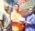Kashif Mohammed centre receives the Church’s Chicken sponsorship cheque from Managing Director Gregory De Gannes (right) while Aubrey ‘Shanghai’ Major (extreme left) looks on. (Orlando Charles photo)   