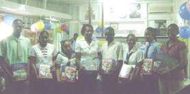 Schools’ representatives pose with copies of the books at Every Child Guyana’s Camp Street office.