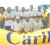 The victorious GCC cricket team poses with their championship trophy while being flanked by two beautiful Carib Girls. (Orlando Charles photo) 