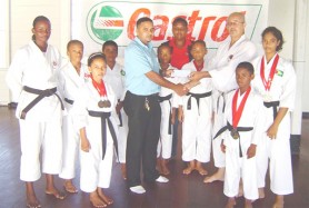 Sensei Amir Khouri receives the cheque from Castrol Brands Manager Leonard Khan while Jacqueline James and some members of the team look on. 