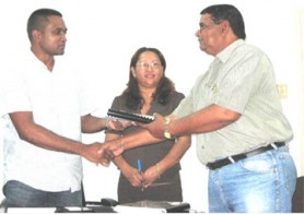 C. Dookie (right) accepting the contract from Permanent Secretary, Nigel Dharamlall as Minister Pauline Sukhai looks on. (GINA photo)