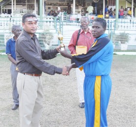 Player of the match! Pamela Lavine receives her trophy from Secretary of the Guyana Cricket Board Anand Senassie while Malcolm Peters, left, and Grantley Culbard look on. 