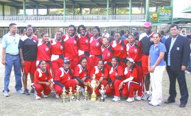 The victorious T&T team poses with their championship trophy with president of the Guyana Cricket Board Chetram Singh (extreme right), WICB women’s cricket representative Jacina Luke and GCB Secretary Anand Sanasie (left). Third from left (stooping) is captain Marissa Aguillera. 