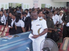 Chief of Staff of the Guyana Defence Force Commodore Gary Best examines the coffin of Dweive Kant Ramdass. 