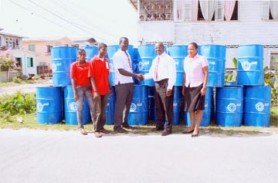 Sol Guyana Inc. General Manager Ken Figaro (second right) presents the bins to Young Leaders of Guyana president Milton Smith in the presence of two youth group members and Ayanna Wickham of Sol (at right). 