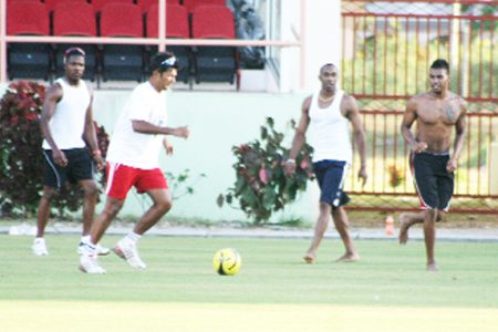CARICOM All Stars players Darren Ganga, Dwayne Bravo and Darren Bravo enjoy a game of football as part of their workout session yesterday at the stadium. 