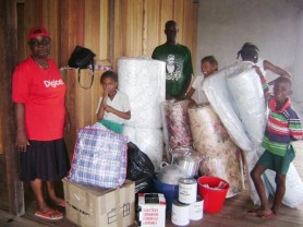 The Fordyce family with the items donated by the GRC. A happy Crystal (between the mattresses) will be able to return to school soon. 