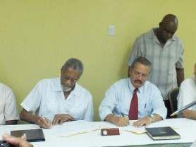 Vice-Chancellor of the University of Guyana, Professor Lawrence Carrington, left, signs the Memorandum of Agreement (MOU) with MACORP’s General Manager, Jorge Medina. 