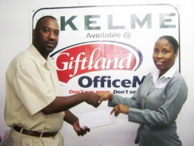 One of Giftland’s Personnel Officer, Wonita Joseph  hands over an undisclosed amount of cash to Frank `English’ Parris. 