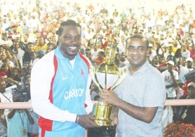 Commander-in-Chief of the armed forces, President Bharat Jagdeo (right) hands over the President’s Premier League Twenty20 Trophy to CARICOM All Stars captain Chris Gayle on Saturday night at the Guyana National Stadium. (Orlando Charles photo)  