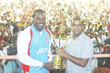 Commander-in-Chief of the armed forces, President Bharat Jagdeo (right) hands over the President’s Premier League Twenty20 Trophy to CARICOM All Stars captain Chris Gayle on Saturday night at the Guyana National Stadium. (Orlando Charles photo)  