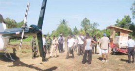 Members of the joint services stand near the GDF helicopter at Abary after the rescue. 