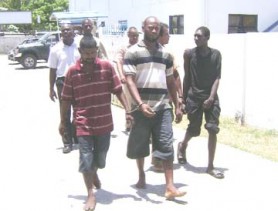 Four of the accused in the kidnapping of Mahaicony rice farmer Parasram Ramnarace and his employee Patrick Skeete, making their way to the Vigilance Magistrate’s Court in the company of policemen yesterday. From left (in foreground) are: Michael Payne called Michael Henry, Denswick Booker called `Garry’, Rajan Persaud called `One Hand’ and Dwaine Johnson called Dwaine King. (Orlando Charles photo)  