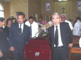 Dr. Raymond Chung (left), bearing the coffin which bore his mother’s body, along  with his cousin Wallace Quan (right) and other relative yesterday  