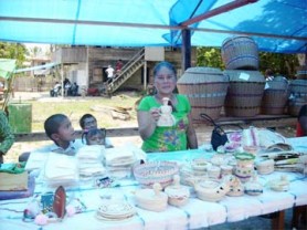 This woman was one of several persons who displayed handcrafted items for sale at the Orealla Heritage day last Friday. In her hand is an ornamental doll made from natural materials. 