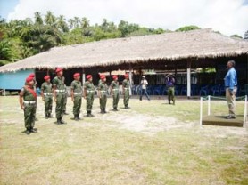 Indigenous members of the Guyana Defence Force last Friday as they prepared to salute Prime Minister Sam Hinds at the Orealla Heritage day celebrations. In the background is the $1.5M benab that was built for the occasion. (Sara Bharrat photo)  