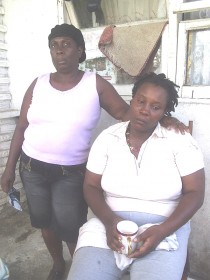 A grieving Denise George (sitting) and a friend at her home yesterday.  