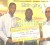 Courts Marketing Assistant Pernell Cummings (left)  presents the cheque to Jerome Khan, captain of Lusignan Golf Club (right) while Troy Peters, Public Relations Officer of the LGC looks on.    