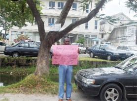 Standing alone: Globe Trust depositor, CS Vaughn protesting yesterday outside the law firm of Senior Counsel Peter Britton at South Road. 