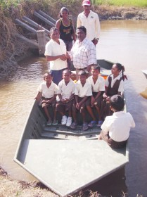 Chairman of Region Five, Harrinarine Baldeo handing over the boat to the head teacher of Abary Primary in the presence of parents and students.
