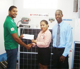 Moen Gafoor receives yet another donation from Starr Computers Supervisor Penny Francis as Leon Belony looks  on.  