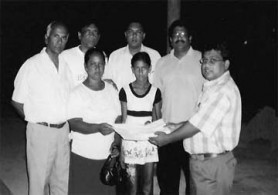 President of the NA Rotary Club, Dr Ganesh Shivkumar presenting the air tickets to Vidyawattie Inderjeet and her mother. 