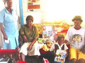 Candacy Britton posing with the items she received in presence of the School’s Welfare Officer Gillian Vyphuis (standing at left); her aunt Waveney Pollydore (right) and her great grandmother; Vida Britton. 