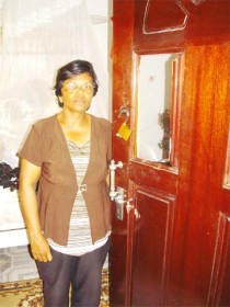 Mrs Jaiwantie Singh stands at the bedroom door which the bandits broke open. 