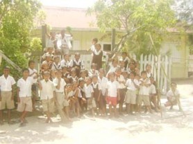 Students of the Capoey Primary School pose in front of their school. 