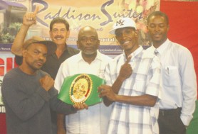 Mauricio Pastrana and Leon Moore pose with the WBC Continental of Americas belt while promoters Carwyn Holland (extreme right) and Stanford Solomon (third from left) along with Pastrana’s trainer/Manager Nelson Lopez look on. (Orlando Charles photo) 