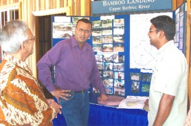 Sheik Niamatali (right) and Rommel Naimatali in discussion with Minister of Agriculture Robert Persaud (centre) near a pictorial display of Variety Woods and Greenheart Ltd’s operations over the years.