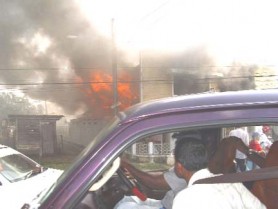 Curious onlookers stop and gaze as the fire gathers momentum. 