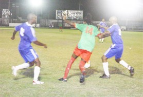 A GDF player at centre fights to maintain possession against two Milerock defenders. (Orlando Charles Photo) 