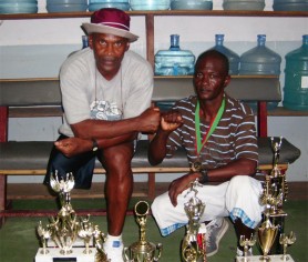 Champion walkers! National race walk champion Rudolph Mitchell (right) poses with his trophies and potential manager William ‘The Conqueror’ France at the Stabroek News building yesterday.  