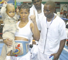 Guyana’s WIBA bantamweight Champion Shondell Alfred with her son Cameron and coach Seibert Blake after winning the title. (Orlando Charles Photo)   
