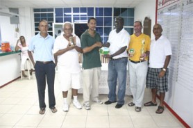 Stabroek News’ Sports Editor Donald Duff, third from right, hands over the first place trophy to Andre Cummings winner of the inaugural de Caires/Mackie Memorial golf tournament which took place yesterday at the Lusignan Golf Club course. Others in photo are from left, Ronald Bulkan, secretary of the LGC, Dr Cecil Ramsingh, second place finisher, William Walker who placed third and Club Captain Jerome Khan.(Orlando Charles photo.)    