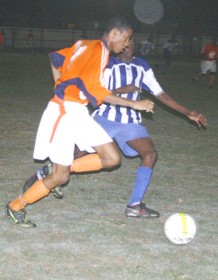 Fruta Conquerors’ Trevon Lycott (left) moves down the flank while being marked closely by a GFC defender. (Orlando Charles photo) 