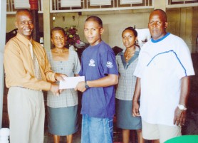 Neil Reece, third from left, receives a cheque from manager of Furniture World Charles Nestor. Others in picture are Roberts, right, and Janet and Barbara Hikel, second from right.    