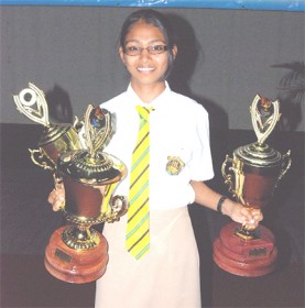 This year’s top CSEC performer, Kia Persaud poses with three trophies awarded her at yesterday’s ceremony. 