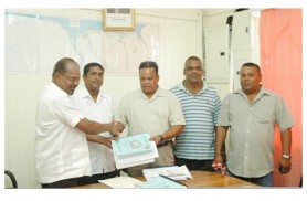 Minister Kellawan Lall (left) handing over the contract document to Mahadeo Umraow of Eagle Transportation and General Construction while other contractors look on. Permanent Secretary of the Ministry Sewchan is second from left.  