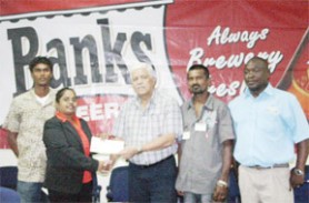 Michael Fung, Banks DIH Power Stout Consultant hands over the cheque to Gomattie Dubaria, treasurer of the Port Mourant Cricket Club. (Orlando Charles photo) 