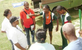 Guyanese cyclist Marcia Dick attempts to explain to the officials that she and her partner Naomi Singh rode the entire course. (Rawle Toney Photo)   