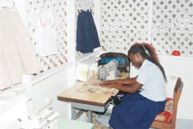 A graduate, Michelle Spencer tries out one of the new sewing machines.