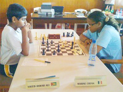 Congratulations Saeed!! National junior chess player Saeed Ali goes in for checkmate against his opponent from French Guiana, Marine Crenn, at the Inter-Guiana Games last weekend in Paramaribo. Playing Board Four for Guyana in a four member team, Saeed won his opponent’s Queen and the game, thereby giving Guyana its first “official” international victory in chess in two decades.