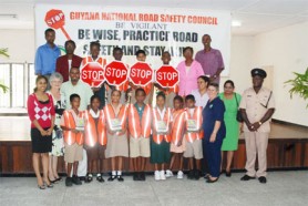 Members of the National Road Safety Council and school children at the launching of the Road Safety School Patrol booklet at the Guyana Red Cross Society building at Eve Leary yesterday. Schools received vests, signs and copies of the booklet.  (Photo by Jules Gibson)
